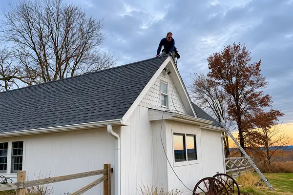 Lightning Protection Installer installing lightning rods on roof